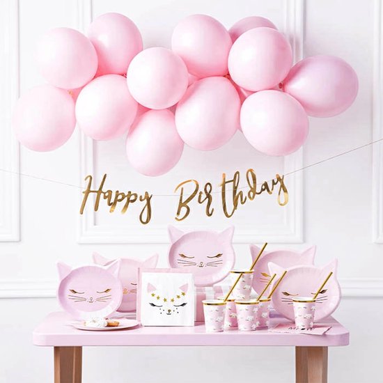 Een roze kindertafel met kattenbordjes, bekertjes, slingers en ballonnen. Goudkleurige 'Happy Birthday' slinger.