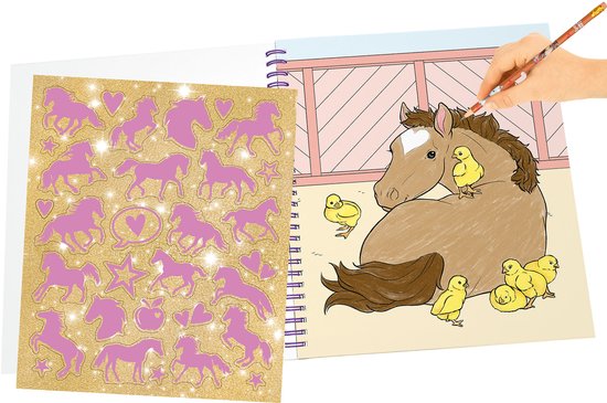 Kleurboek met paarden en kuikens. Een hand kleurt een paard met een kwast. Glimmerende paardenstickers ernaast.