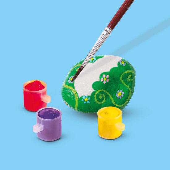 Steen groen beschilderd met bloemetjes, met penseel en drie potjes verf in rood, paars en geel.