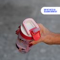 Gros plan d'une bouteille Kambukka rose avec imprimé de chiens, le couvercle et la paille sont visibles. Le texte 'DOOP MET RIETJE EN SILICONEN DRINKTUIT' est visible.