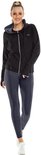 Model in zwart vest met capuchon, wit sporttopje en donkergrijs legging.