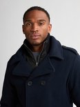 Close-up van een man met donkerblauwe peacoat met dubbele rij knopen en staande ribkraag.