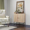 Een houten dressoir met visgraatpatroon op de deuren, naast een fauteuil met bloemenprint en een wanddecoratie met bloemen.