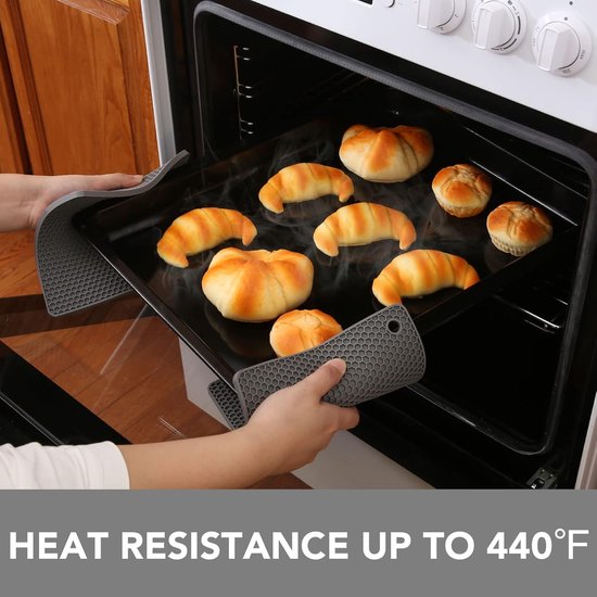 Grijze, hexagonale siliconen onderzetters die worden gebruikt om een bakplaat met croissants uit een oven te halen.