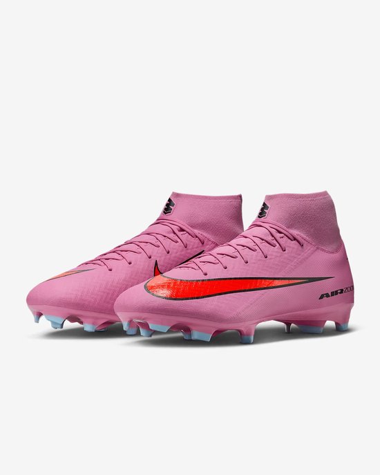 Roze middenhoge voetbalschoenen met oranje swoosh.
