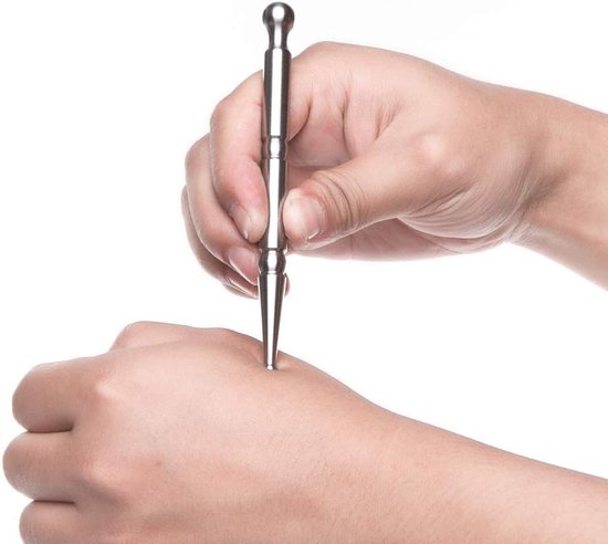 Zilverkleurige massagepen met ronde en puntige uiteinden, gebruikt op een hand.