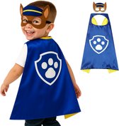 Jongetje met een Chase-kostuum, met blauwe cape met Chase's badge en een bruin masker, naast het kostuum.