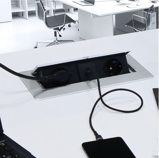 Zilveren inbouw stekkerdoos met 2 stopcontacten, 1 USB-A en 1 USB-C poort, aangesloten op een laptop en smartphone.