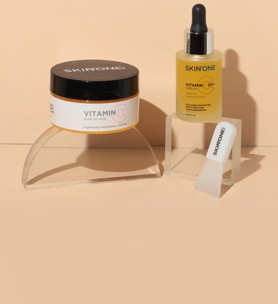 SKINONE vitamine C glow mask potje en een SKINONE vitamine C serum flesje op display.