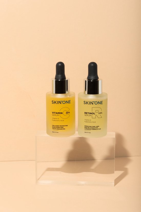 Twee glazen flesjes: SKINONE vitamine C serum (geel) en SKINONE retinol serum (lichtgeel).