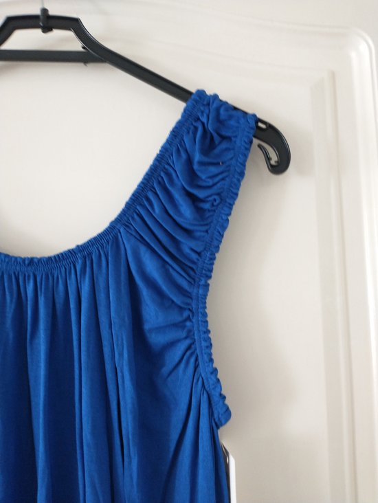 Koningblauwe top met off-shoulder halslijn en gerimpelde details, gedragen op een kledinghanger.