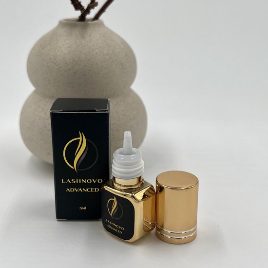 LASHNOVO ADVANCED 5ml wimperlijm in gouden flesje met zwarte, gouden label. Naast een zwart doosje.