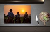 Inductieplaat Beschermer - Achteraanzicht van Drie Cowboys op Paarden tijdens Felle Zonsondergang - 80x55 cm - 2 mm Dik - Inductie Beschermer - Bescherming Inductiekookplaat - Kookplaat Beschermer van Wit Vinyl