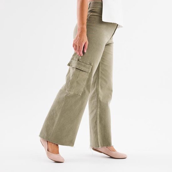 Femme portant des ballerines roses et un pantalon cargo vert large.