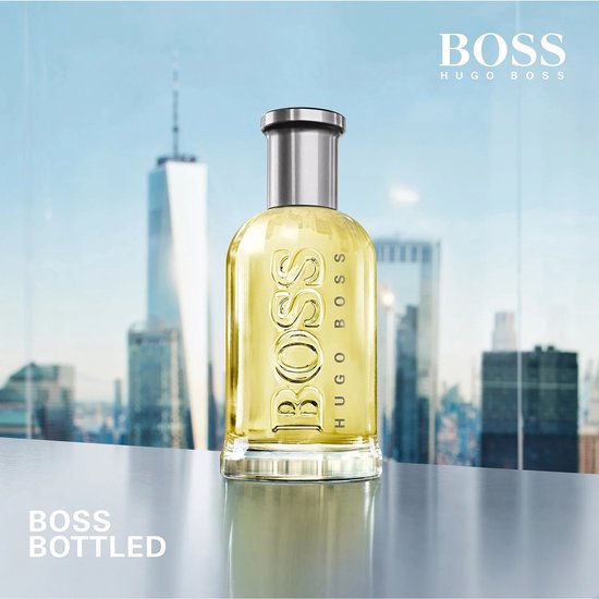 Een BOSS Bottled parfumfles met een stad op de achtergrond.