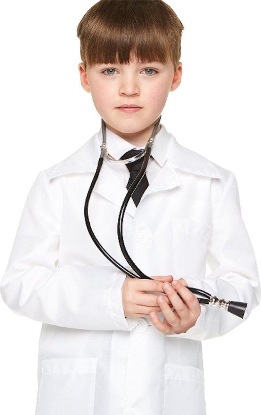 Garçon aux cheveux bruns portant une blouse blanche de médecin, une chemise noire et une cravate noire, avec un stéthoscope dans les mains.