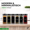 Moderne en minimalistische kruidenpotjes van glas met zwarte deksels, gevuld met verschillende kruiden zoals kurkuma en oregano.