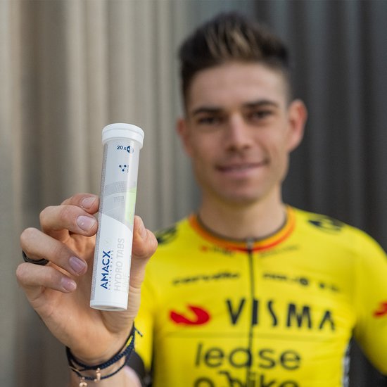 Man in geel wielershirt houdt een tube Amacx Hydro Tabs Forest Fruit vast.