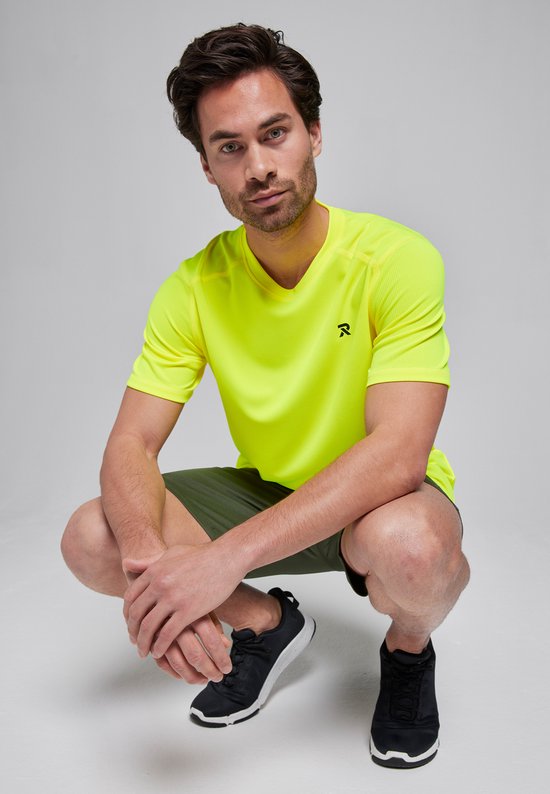Man in actieve pose, draagt limegroen sportshirt en donkergroene sportbroek. Zwart recycling-symbool zichtbaar.