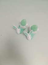 2 decoratieve paashazen met een verlicht groen ei