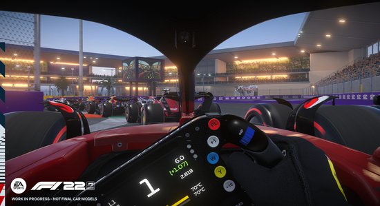 Eerste persoonsweergave van een Formule 1-auto met racestuur en een startgrid op de achtergrond.