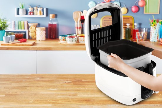 Handen halen een grijze binnenpan uit een witte Tefal frituurpan.
