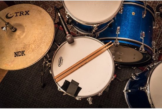 Zwarte microfoon op een snare drum, met drumstokken en een bekken.