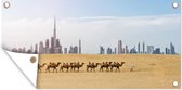 Wanddecoratie buiten Kamelen die in de woestijn voor Dubai langslopen - 160x80 cm - Tuindoek - Buitenposter