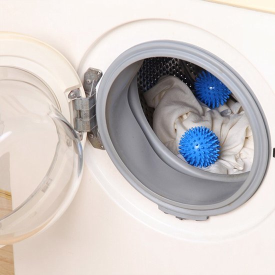Deux boules de sèche-linge bleues avec des picots dans un lave-linge avec du linge blanc.