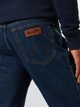 Close-up van de achterkant van jeans met een bruine leren Wrangler-patch en de kenmerkende 'W'-stiksels.