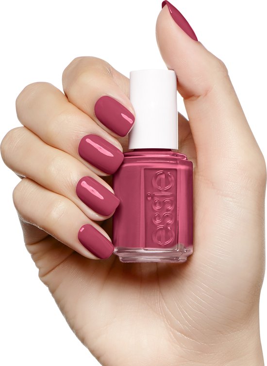 Hand met lichte huidskleur die een flesje Essie nagellak vasthoudt. Nagels gelakt in roze.