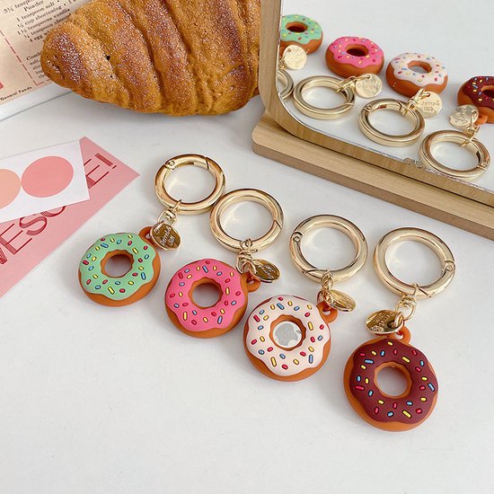Vier donut sleutelhangers: groen met stippen, roze met stippen, wit met stippen en bruin met stippen.