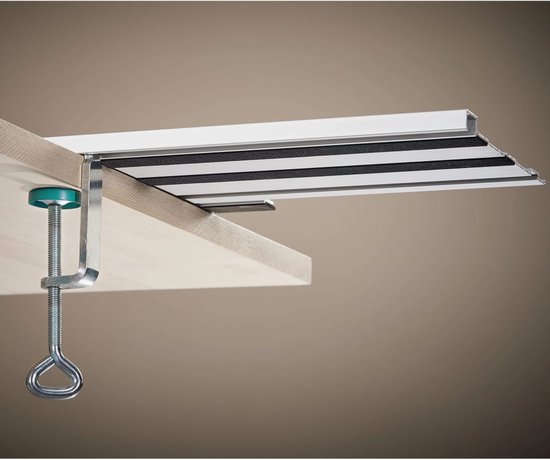 Grijze C-klem met groene schijf klemt een metalen profiel op een houten plank.