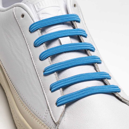 Close-up van een witte leren sneaker met lichtblauwe, elastische U-Lace veters.