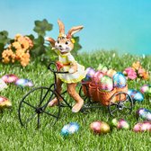Lapin de Pâques avec tricycle et œufs en chocolat