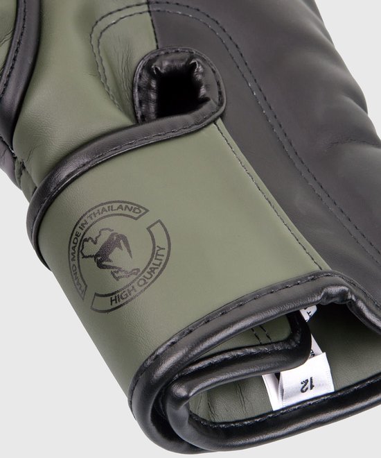 Detail van khaki bokshandschoen met tekst "Hand made in Thailand" en "High Quality".