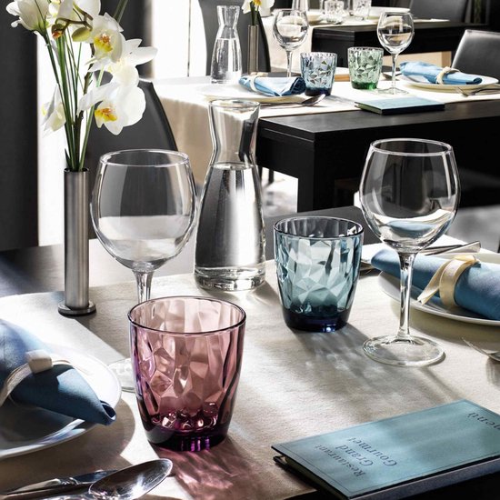 Gedekte tafel met Bormioli Rocco Diamond tumblers in paars en blauw, naast wijnglazen en karaf.
