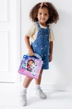 Une fille en salopette tenant un livre d'activités Gabby's Dollhouse.