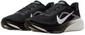 Paar zwarte Nike hardloopschoenen met witte Swooshes en witte zool, van opzij gezien.