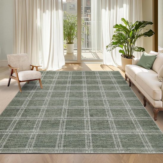 Groot groen vloerkleed met wit ruitpatroon in een zonnige woonkamer bij een beige bank en fauteuil.