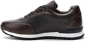 Bruine leren sneaker met contrasterende donkerdere panelen en een witte zool.