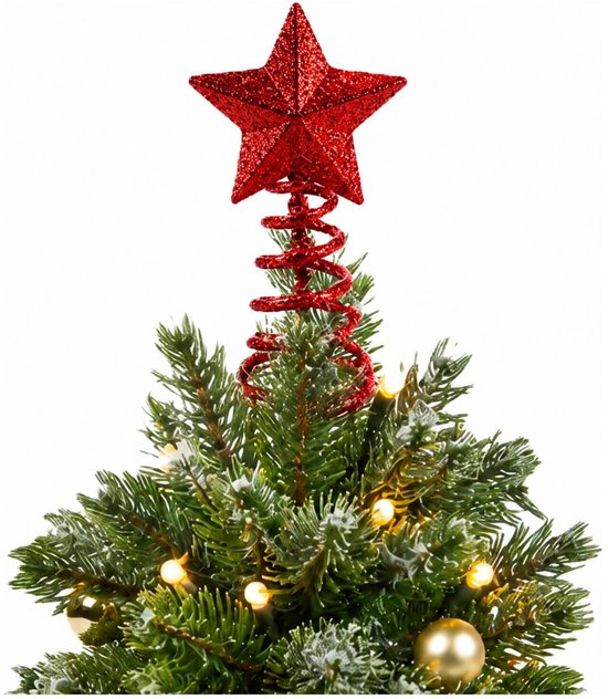 Rode glinsterende ster piek op de top van een kleine kerstboom met lichtjes en gouden ballen.