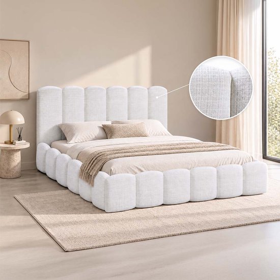 Lit double blanc rembourré avec tête de lit et pied de lit cannelés, avec zoom sur le tissu blanc.