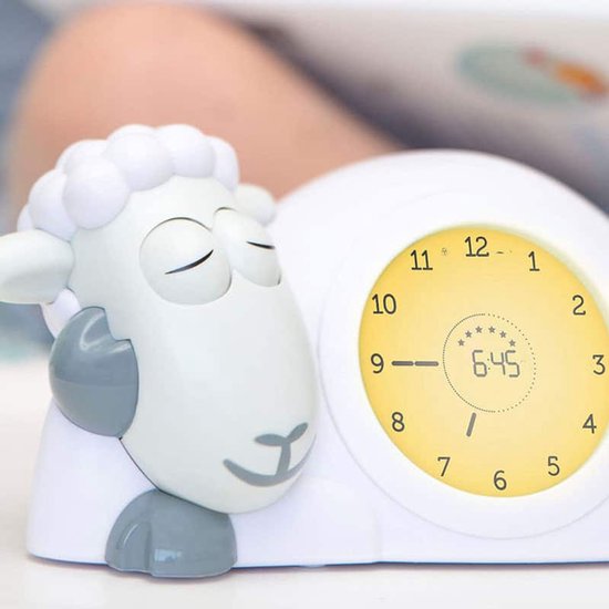 Grijze schaap wekker met gesloten ogen en gele verlichting.