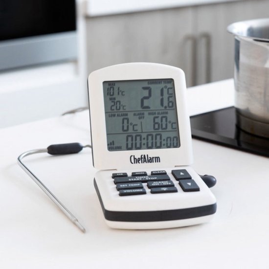 Witte ChefAlarm thermometer met roestvrijstalen sonde, staand op een aanrecht naast een pan.