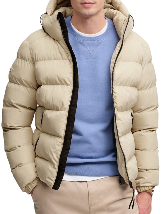 Lichtbeige pufferjack met capuchon, ritssluiting en blauwe trui.