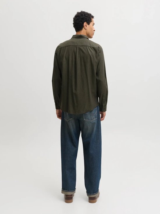 Achterkant van het donkergroene overhemd op een model, gecombineerd met een wijde spijkerbroek.