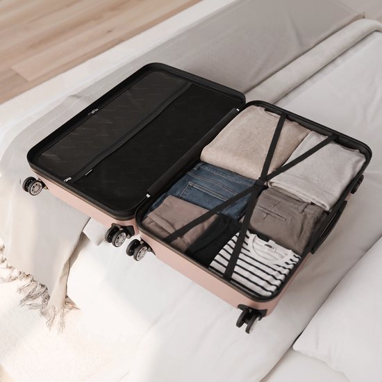 Een open rosegouden koffer op een bed, gevuld met kleding.
