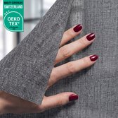 Grijze textiel raamfolie met een maaspatroon, aangeraakt door een hand met donkere nagellak. OEKO-TEX label in de hoek.