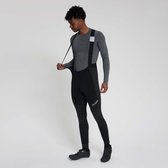 Man met grijze longsleeve en zwarte fietsbroek met bretels, hij trekt aan de bretel.
